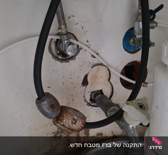 צנרת מתחת לכיור עם סימני חלודה ונזילה